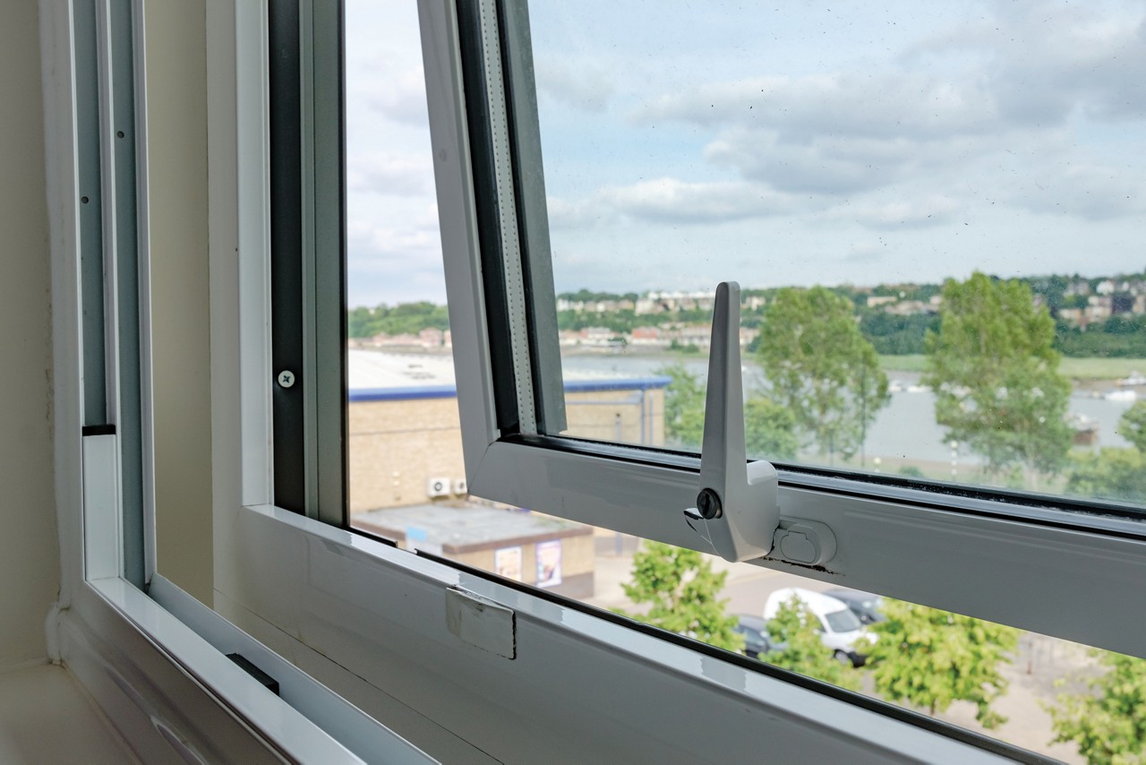 Close-up of a newly installed double glazing system installed in an apartment. Outside can be seen a semi rural location with a distant river in the United Kingdom.
